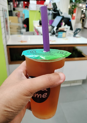 Iced Chatime fruit tea held in front of the kiosk